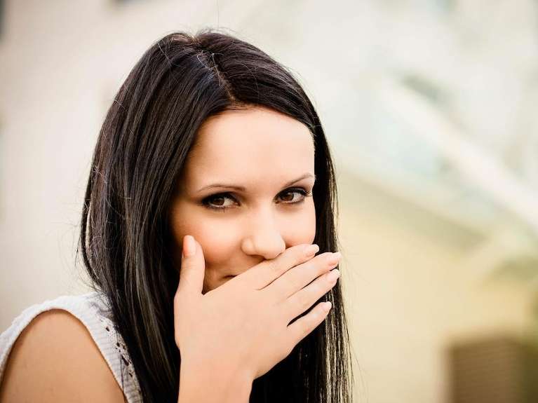 dentist milwaukee | woman covering mouth