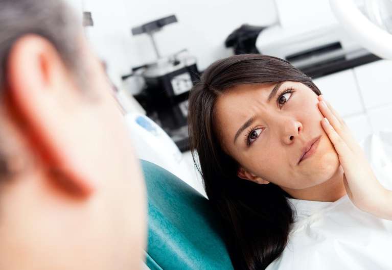 woman with toothache visiting the emergency dentist in Milwaukee