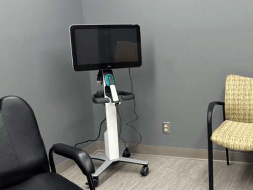 iTero digital scanner on mobile cart with large display screen in dental consultation room